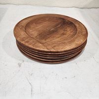 Stack of six round teak plates