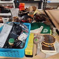 Wide view of lot on table showing basket, mirrors, hat, bowl, sunglasses, yellow box