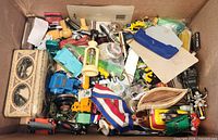 Top view of box showing variety of toys, tin, stamps, ribbon medal and other small items