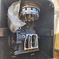 Engine block inside crate showing clutch basket and gears