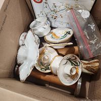 Box containing assorted porcelain pieces and candlesticks