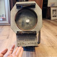 Front view showing glass lens, octagonal housing, manufacturer plate