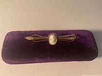 Front view showing cameo, seed pearls and gold bar design on velvet pad