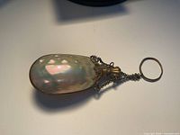 Full view of baroque pearl perfume bottle showing chain and ring