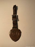 Front view of fob on leather strap showing seal details