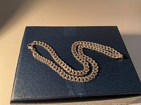 Necklace laid flat highlighting curb links