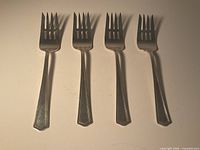 Four sterling silver dessert forks full view