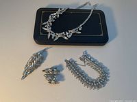 Full set laid out: necklace, bracelet, brooch, earrings