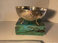 Side view showing bowl on three feet and eagle crest