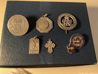 Front view of all five medals and pins laid out