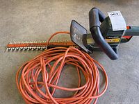 Hedge trimmer with coiled extension cord