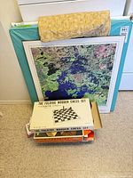All items stacked: card tables, map, quilted cover, chess set box, board game