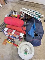 Pile view of chairs, air bed boxes, duffel, hatchet, propane cylinder