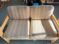 Front view of striped fabric loveseat showing cushions and wood frame