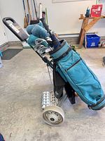 Golf bag mounted on pull cart holding assorted clubs