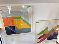 Both framed prints hanging on wall showing size and design