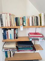 Four wall shelves filled with approximately 50 books