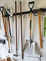 Group of seven garden tools hanging on rack