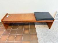 Top view of brown wood bench and black cushion