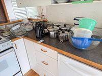 Countertop view showing pots, glass bakeware, thermos, plastic bowls and storage containers