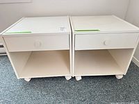 Front view of both nightstands showing drawers, open shelves and casters