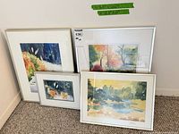 All four framed watercolor paintings leaning against wall