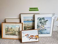 Group shot showing all five framed watercolor artworks leaning against wall