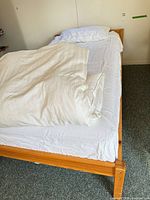 Overall view of assembled solid wood twin bed with white bedding