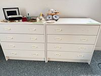 Two matching white dressers side by side showing drawer fronts and handles