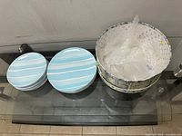 Two plate stacks and storage box on glass table