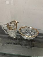 Pitcher and bowl side by side showing design details and gold trim