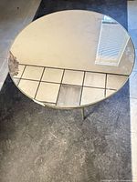 Top view of round mirrored coffee table, showing mirror surface and damage