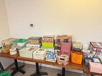 overview of assorted gift boxes, plastic bins, wicker basket and canister on tables