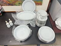 Overall view showing stacked plates, bowls, platters, cup and three small condiment pieces