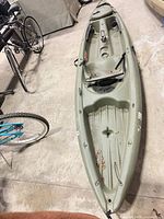 Top view of olive-green Pelican sit-on-top kayak showing seat area, footrests, bow hatch