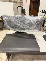 Front view of Planar monitor wrapped for protection on its stand