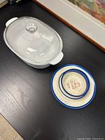 Oval casserole dish with lid and two ceramic dishes on table