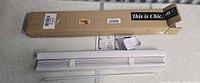 Boxed and unboxed blind showing slats, wand, and hardware