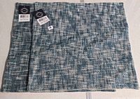 Pair of blue-white Surya pillow covers folded with tags visible