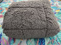Folded grey plush weighted throw blanket