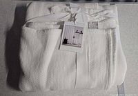 Full folded shower curtain with ribbon and hang tag visible