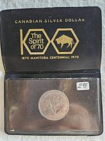 Plastic display case closed, front lettering and coin visible