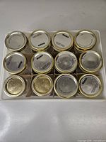 Top view of 12 jars in tray, lids visible