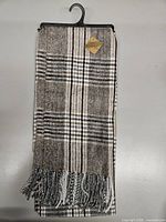 Folded plaid shawl with fringe on hanger