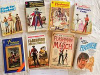 Eight of nine paperbacks laid out showing front covers