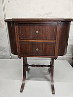 Front view of knitting table showing drawers, legs, missing brass foot