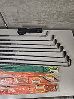 Full view of eight Mizuno irons, Daiwa rod case, four packaged kites