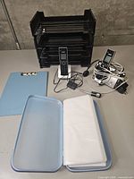 Full lot showing desk trays, phones, clipboard, photo case