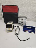 Lot overview showing flashlight, pencil sharpener, mini drawers, binder, Parker pen case