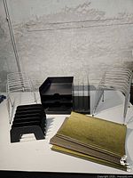 Group shot showing two wire organizers, black two-tier tray, black vertical sorter and stack of hanging folders